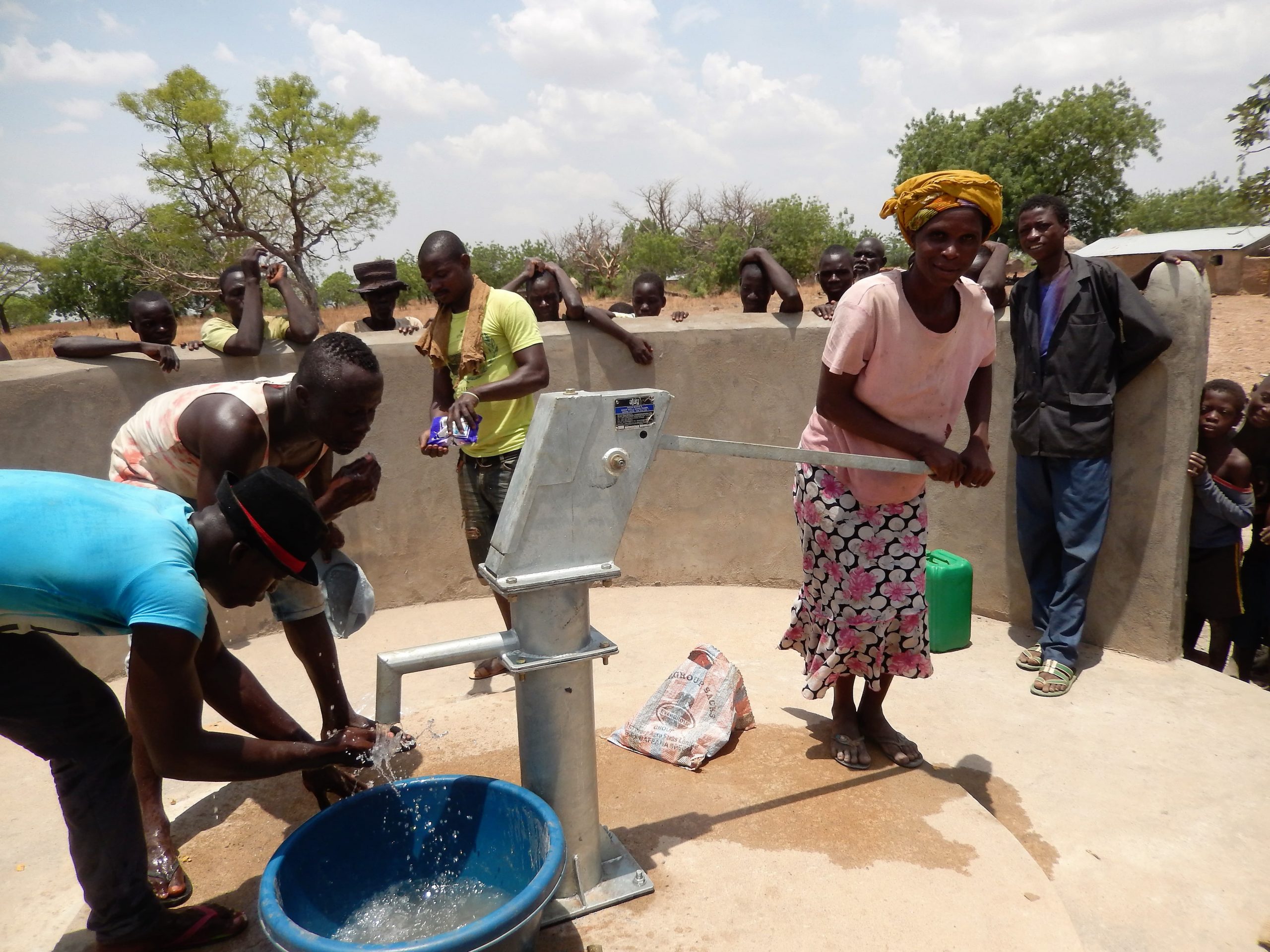 Eine Frau bedient eine Wasserpumpe
